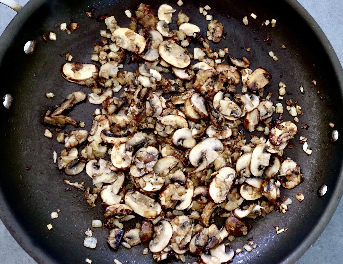 Portuguese-Style Sausage-with-Mushrooms Skillet full with cooked sliced mushrooms and diced onion.