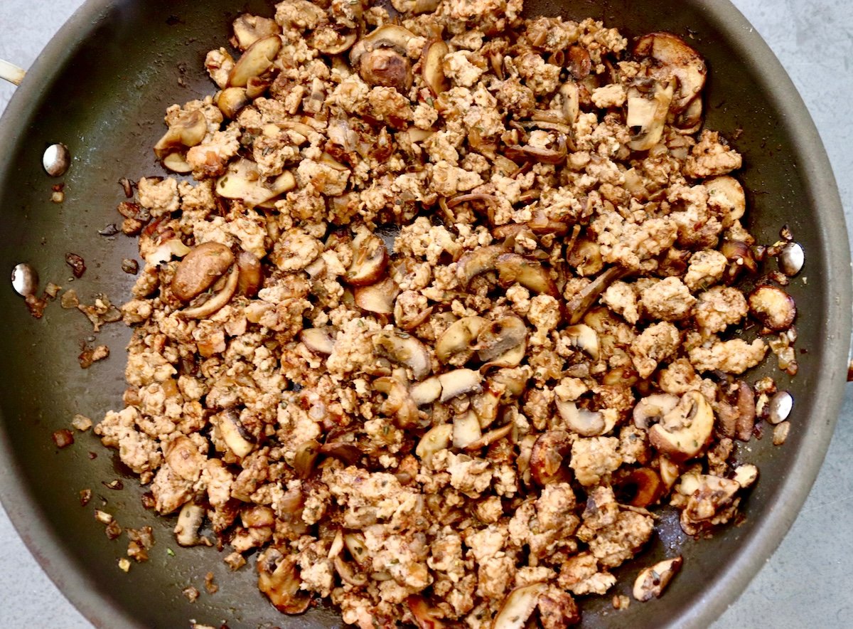 Portuguese-Style Sausage-with-Mushrooms Cooked ground pork with onion and mushrooms in a skillet.