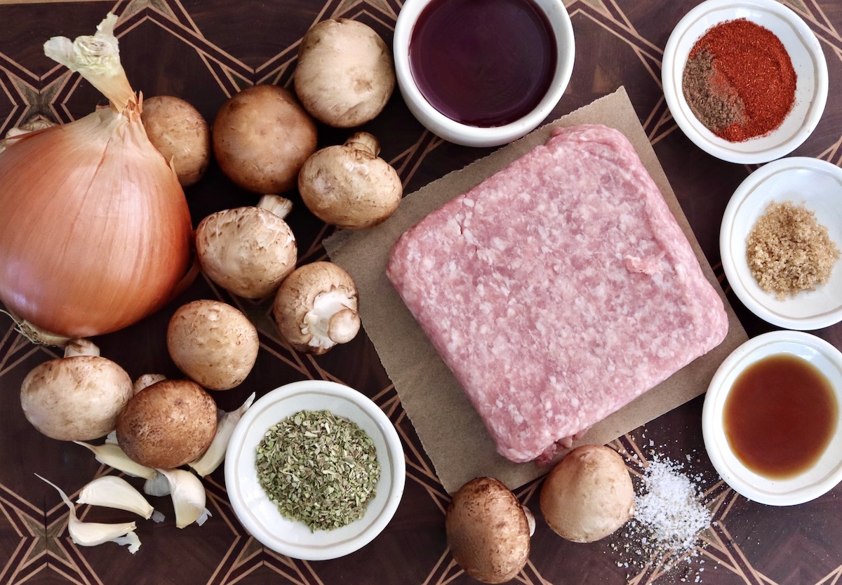 Portuguese-Style Sausage-with-Mushrooms Ingredients for Portuguese sausage including raw ground pork, mushrooms, onion, garlic, oregano, liquid smoke, red wine and paprika.