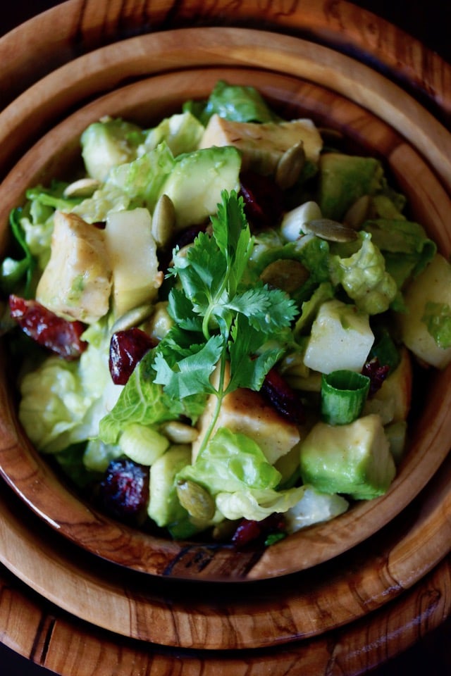 Chicken Apple Salad Recipe with Cranberries in wooden bowl with cilantro sprig
