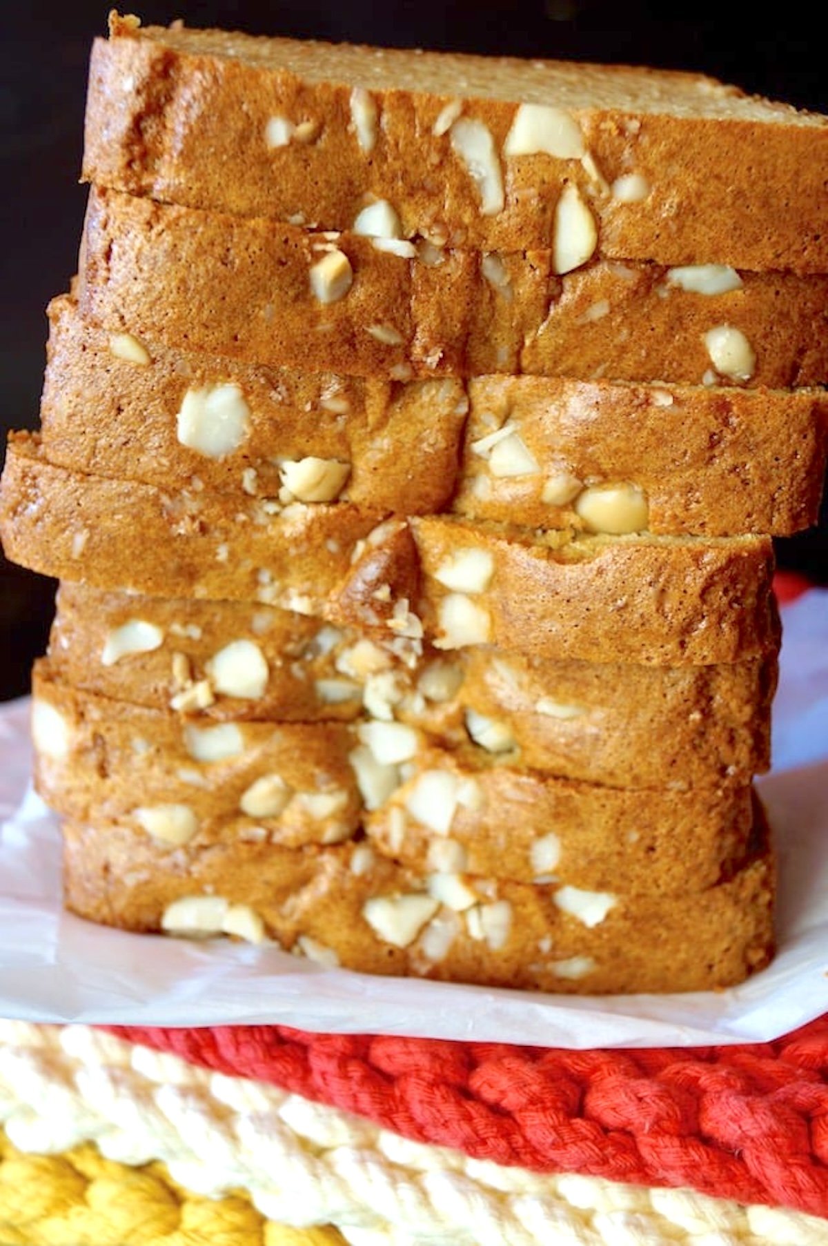 Tall stack of sliced Macadamia Bread on parchment paper.