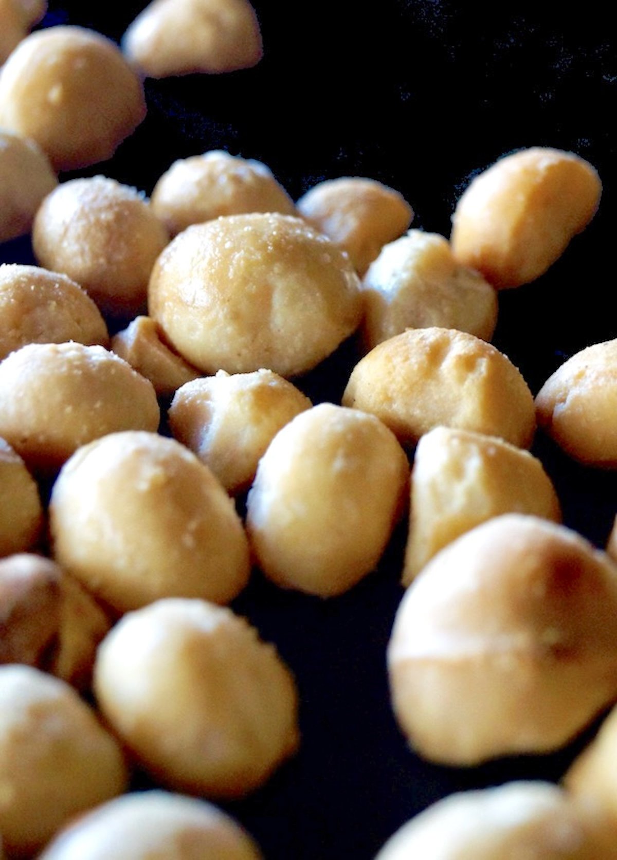 Sheet pan with macadamia nuts that have been roasted.