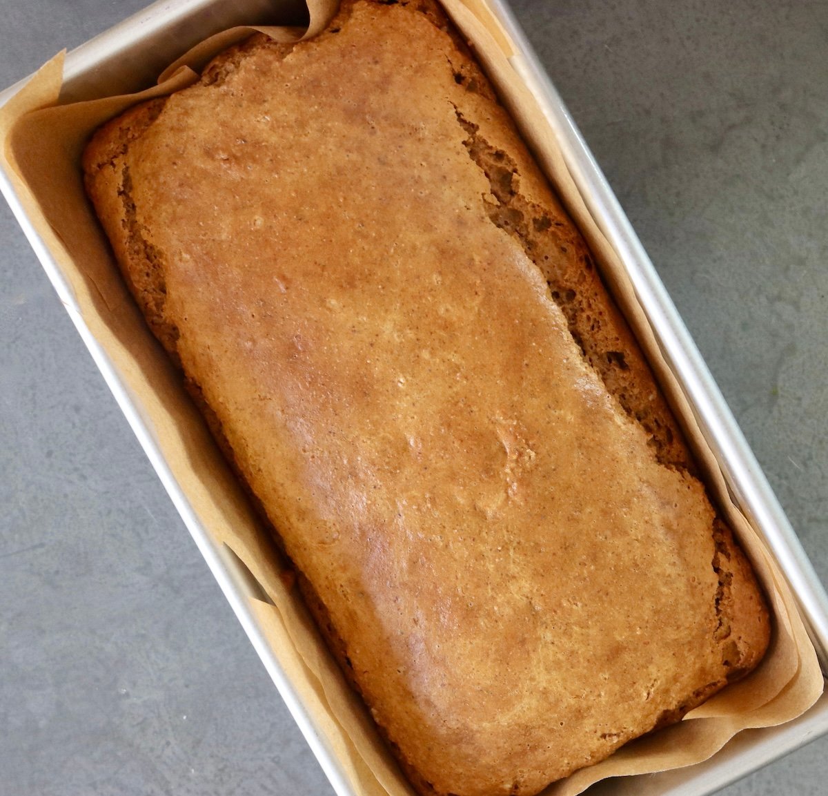 Baked almond butter bread in a loaf pan.