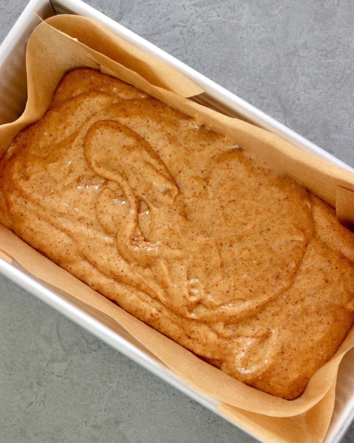 Batter for almond butter bread in a loaf pan. 