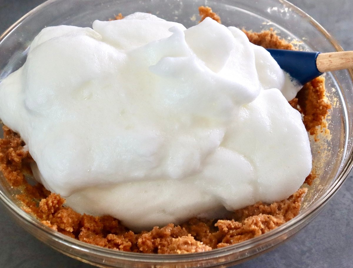 Stiff egg whites on top of almond butter mixture for bread.
