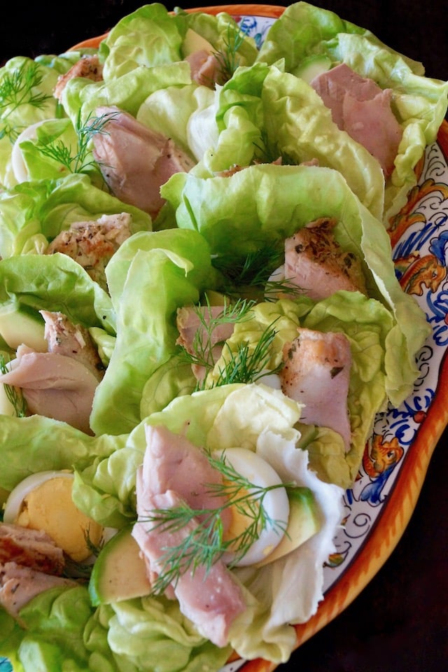 pretty Italian, bule and gold patterned platter with lettuce, fresh dill and sliced, hard boiled eggs, and tuna
