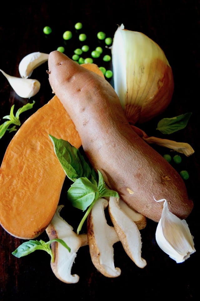 raw sweet potato, mushrooms, onion, peas and garlic for Skillet Sweet Potato Chicken Recipe