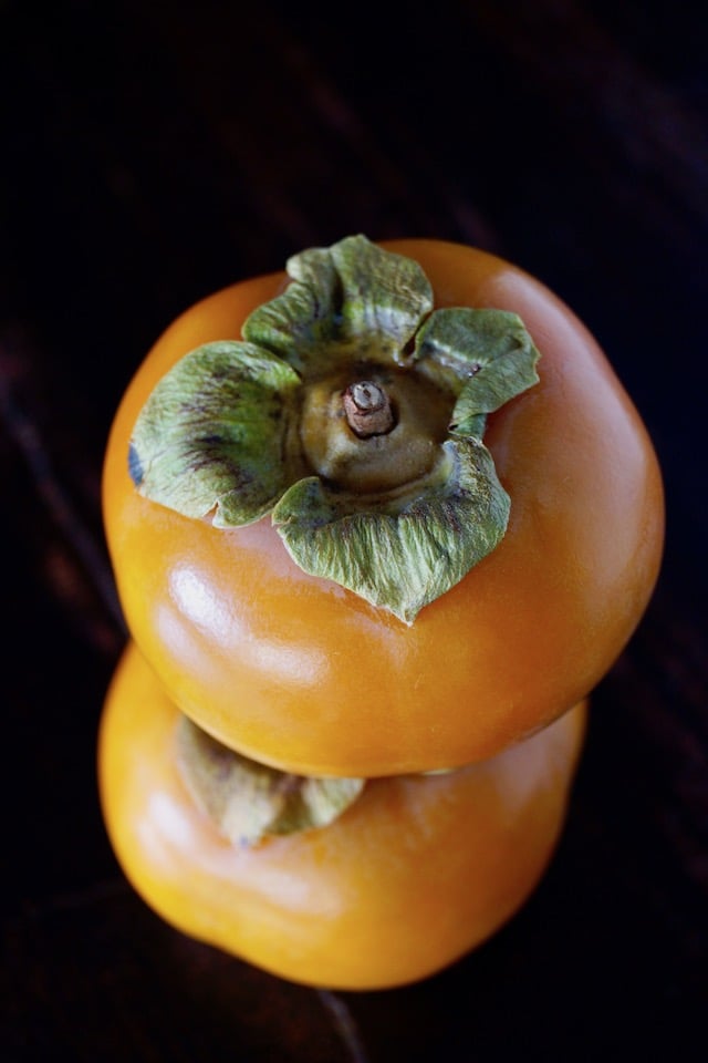 two Fuyu persimmons, one on top of the other for Persimmon Prosciutto Pork Tenderloin Recipe