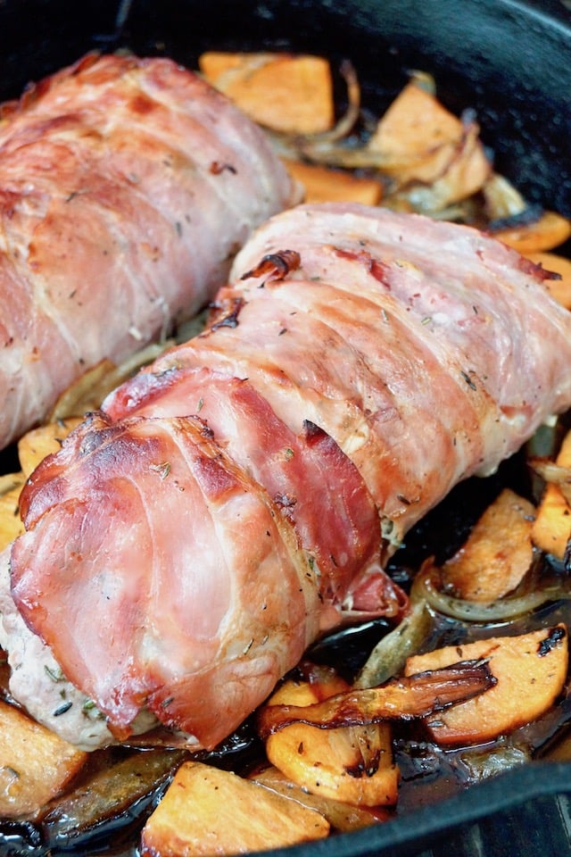 prosciutto wrapped pork tenderloin in saute pan with persimmon slices