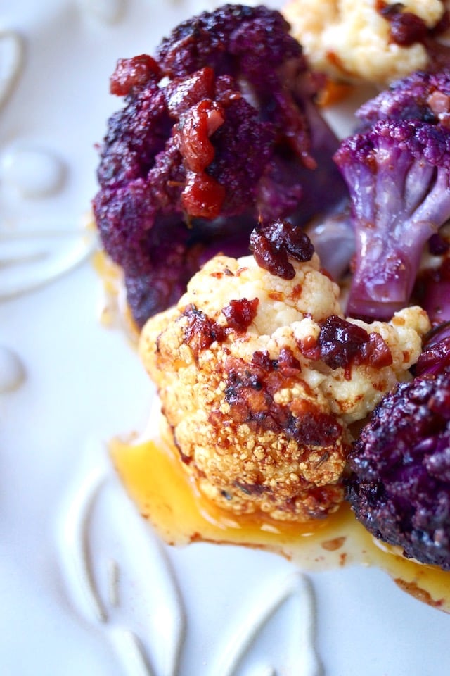 roasted flowerets of purple and white cauliflower with a red sauce over them