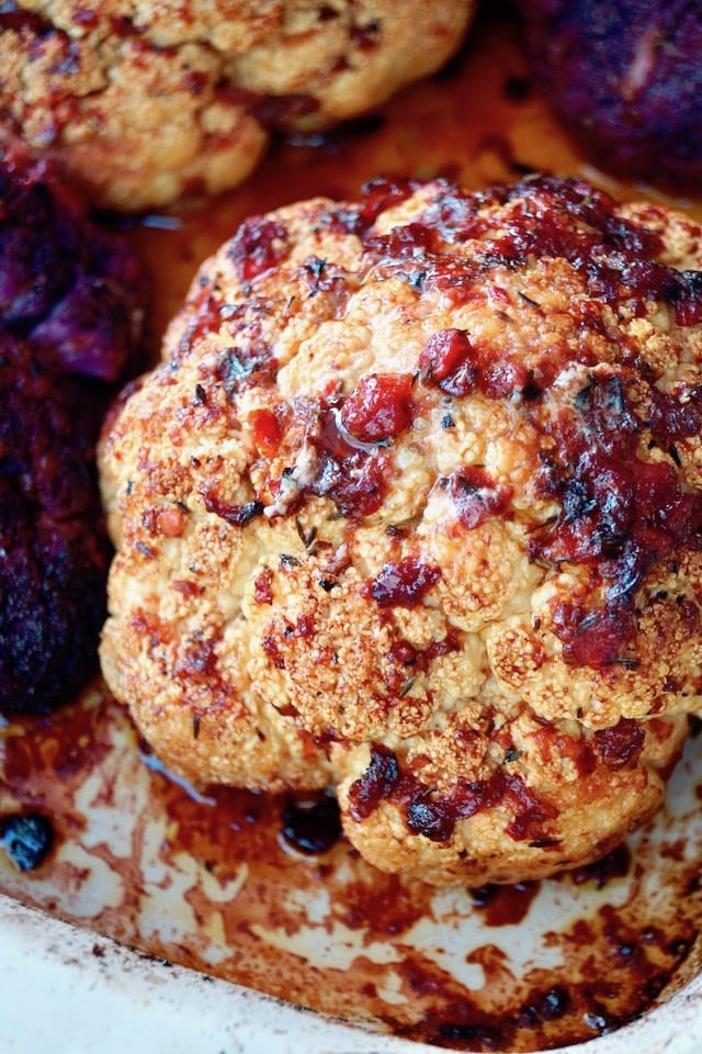 whole roasted cauliflower with bits of red pepper and light red sauce