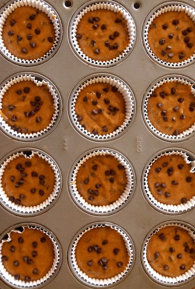 Gluten-free peanut butter banana muffin batter in a muffin tin, filling the papers ¾ the way up.