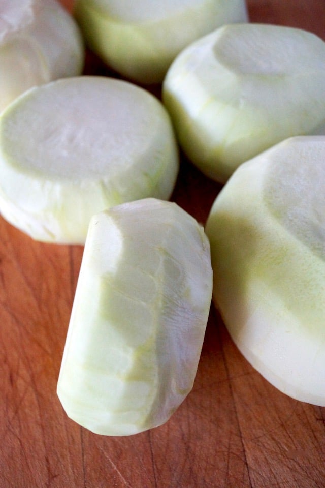 Several whole, peeled Kolhrabi on a cutting board for Roasted Kohlrabi