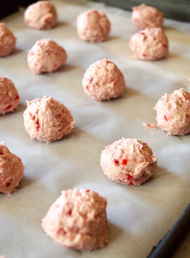 Several balls of Valentine's Day Raspberry Chocolate Cookie dough on parchment.