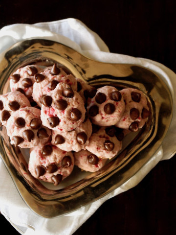 heart-shaped silver dish filled with small raspberry chocolate chip cookies