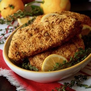 bowl with a few fried chicken breasts with lemons