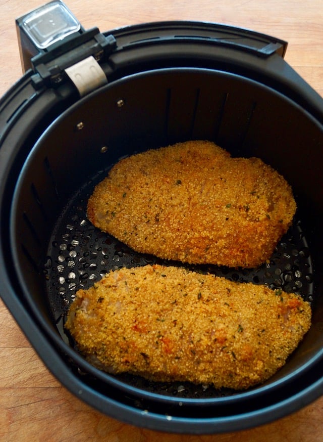 2 golden brown, crispy chicken breasts in air fryer basket, for Air Fryer Gluten-Free Lemon Fried Chicken.