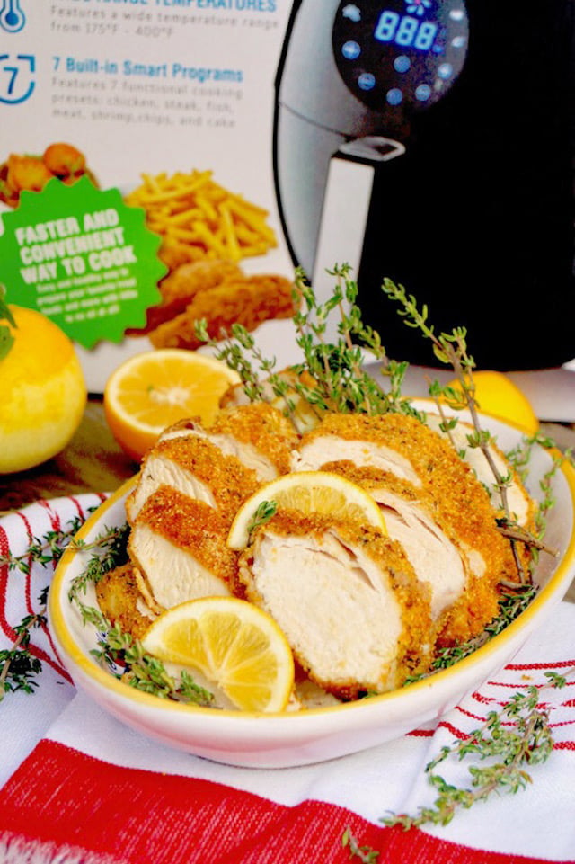 Sliced Air Fryer Gluten-Free Lemon Fried Chicken breasts in a yellow rimmed dish with GoWISE USA box.