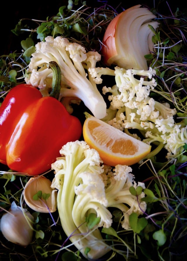 Ingredients for Lemon-Marinated Fioretto Salad Recipe, including red pepper, lemon, garlic, onion and the flowering cauliflower.