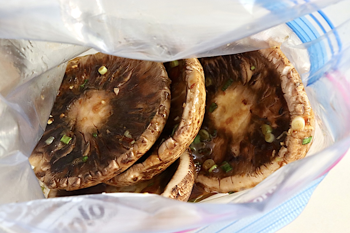Marinated-Grilled-Portobello-Mushrooms A few portobello mushrooms in a ziploc bag with an Asian mariande.