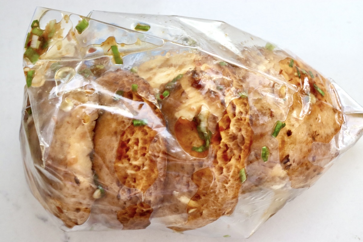 Marinated-Grilled-Portobello-Mushrooms A few portobello mushrooms in a sealed ziploc bag with an Asian mariande.