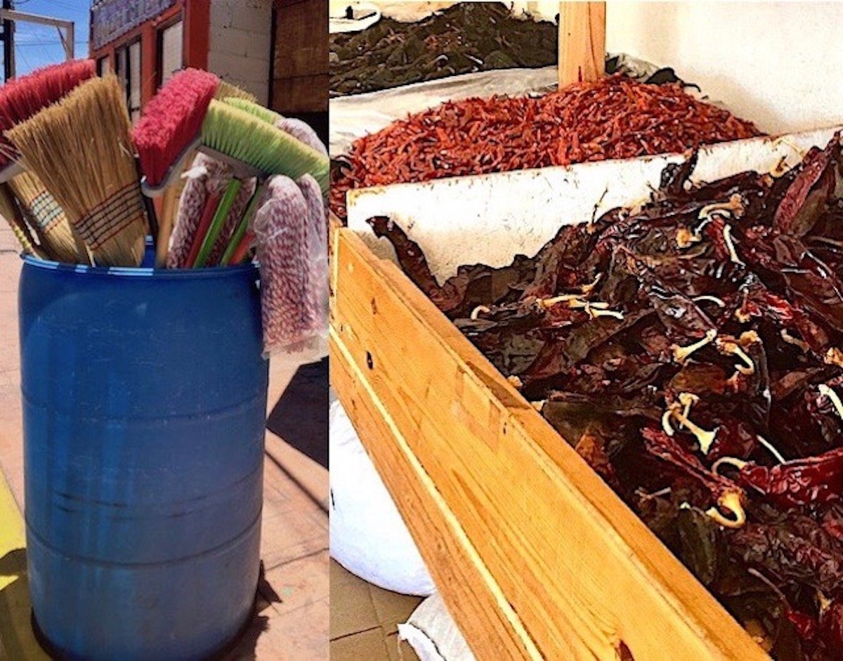 Brooms sticking up out of a blue trashcan and bins of dried peppers in Semillas y especias El Gavilan in Loreto, Mexico.