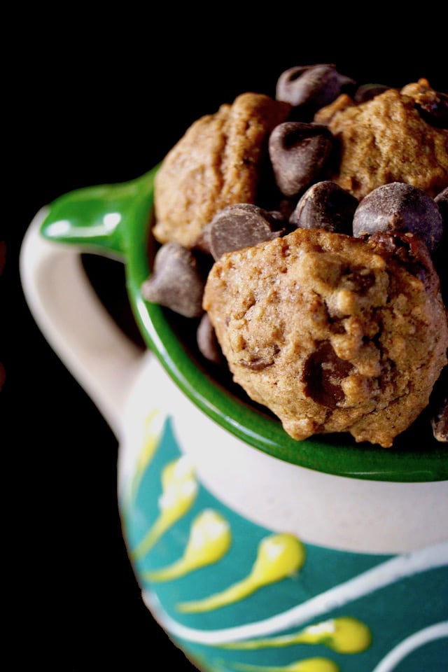 Close up of half of a pretty ceramic, green and yellow mug with Small Mexican Chocolate Spice Cookies in it.