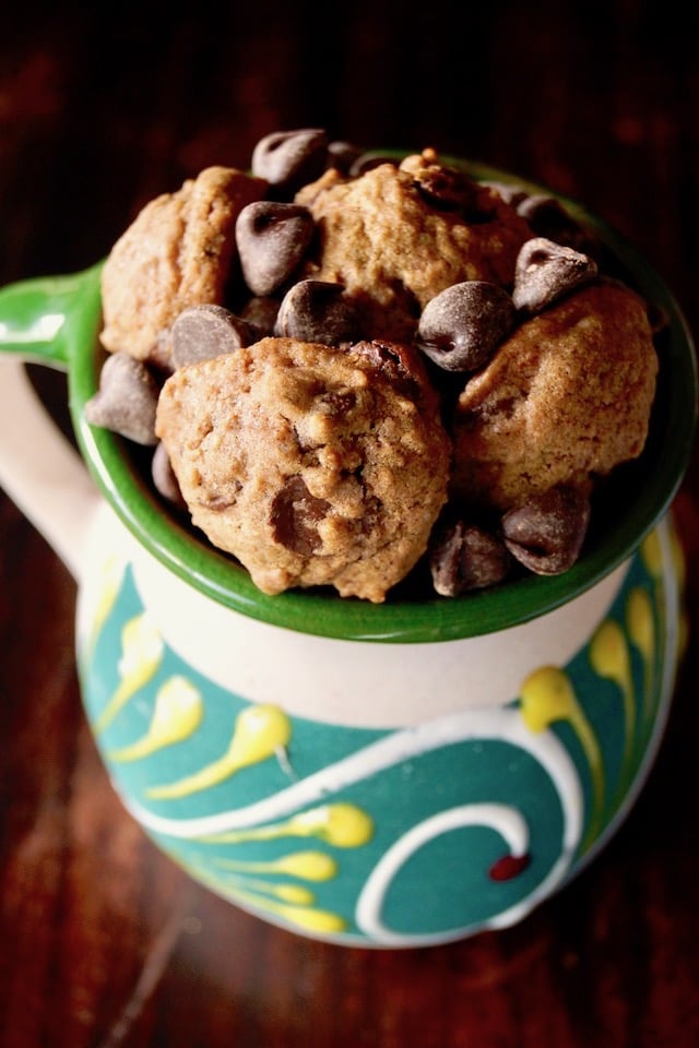 Close up of Small Mexican Chocolate Spice Cookies in a pretty ceramic green, cream and yellow mug.
