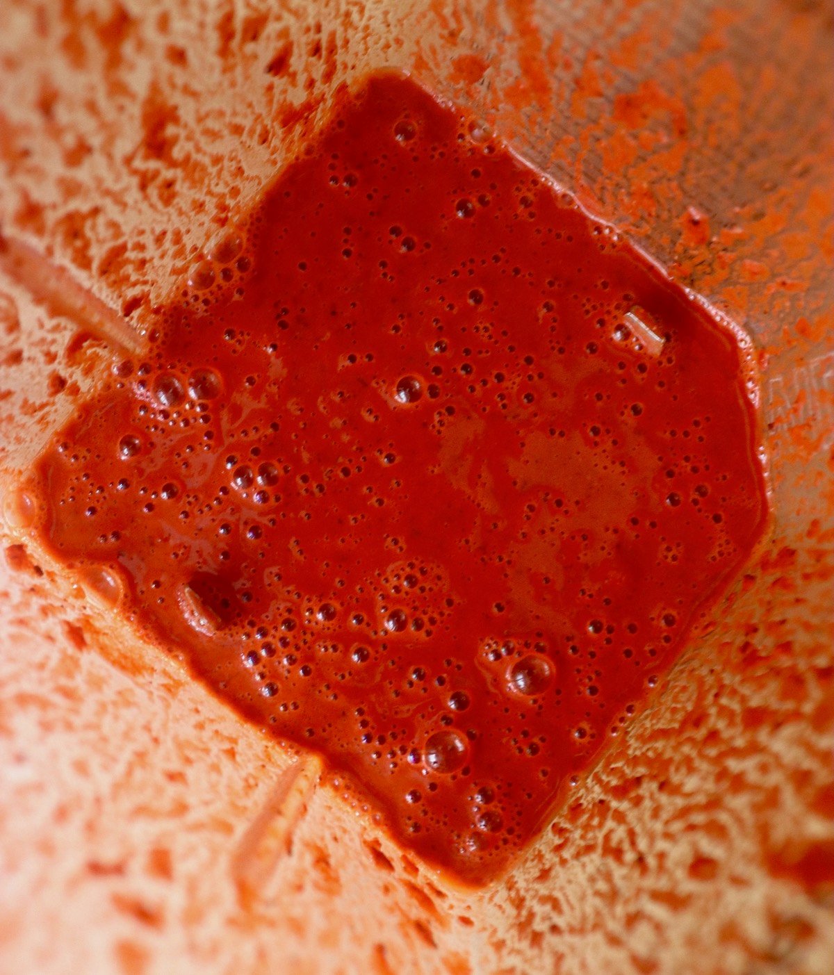 Blender with brick-red achiote sauce.