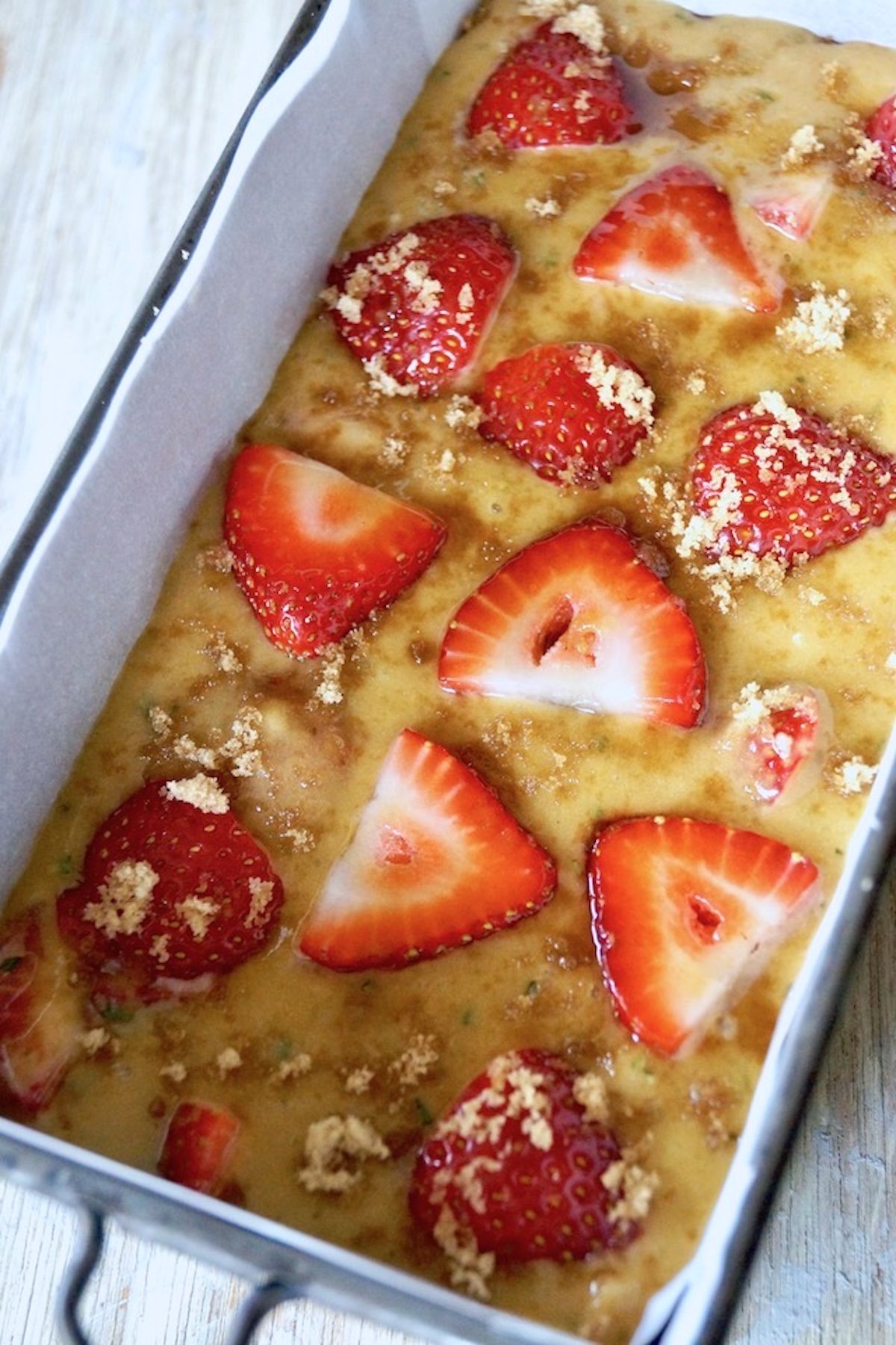 Raw batter for strawberry cake in loaf pan.