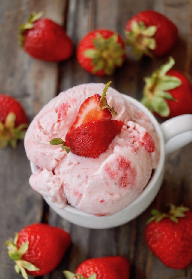 Top view of Strawberry Swirl No-Churn Ice Cream in a small white mug with strawberry on top.