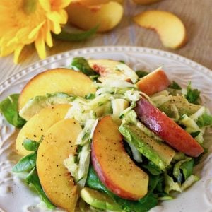 Composed Peach Avocado with Zucchini on a white plate with a yellow daisy behind it.