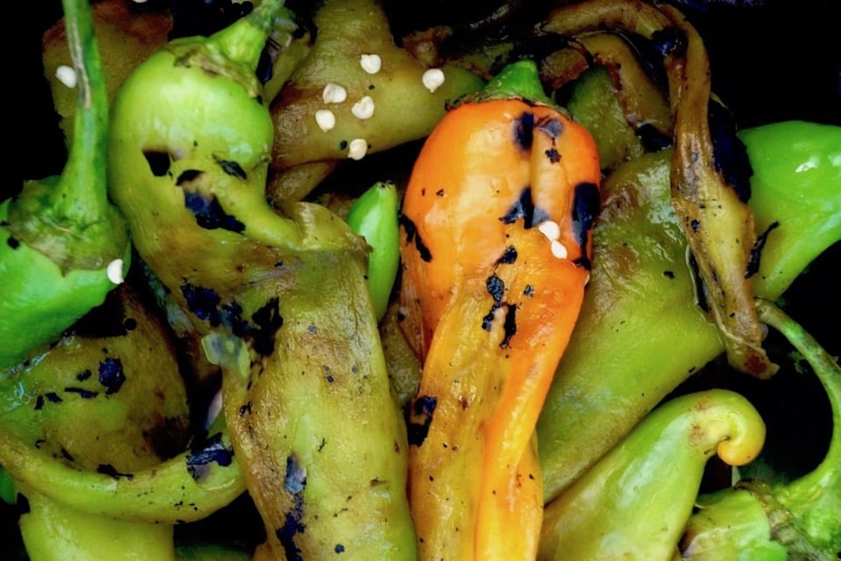 Several red and green roasted hatch chiles mixed together.