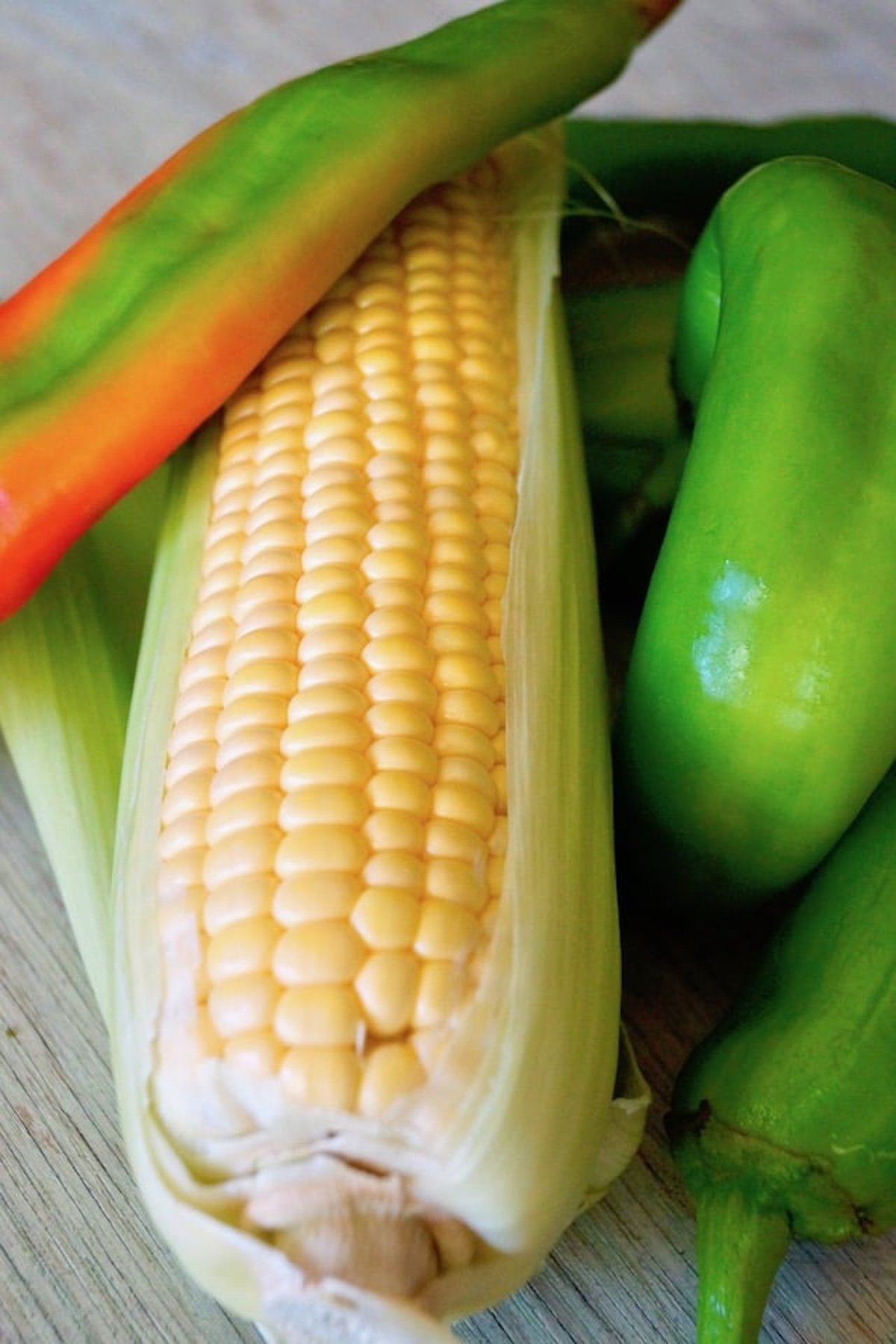 Corn on the cob with a few green and red hatch chiles.