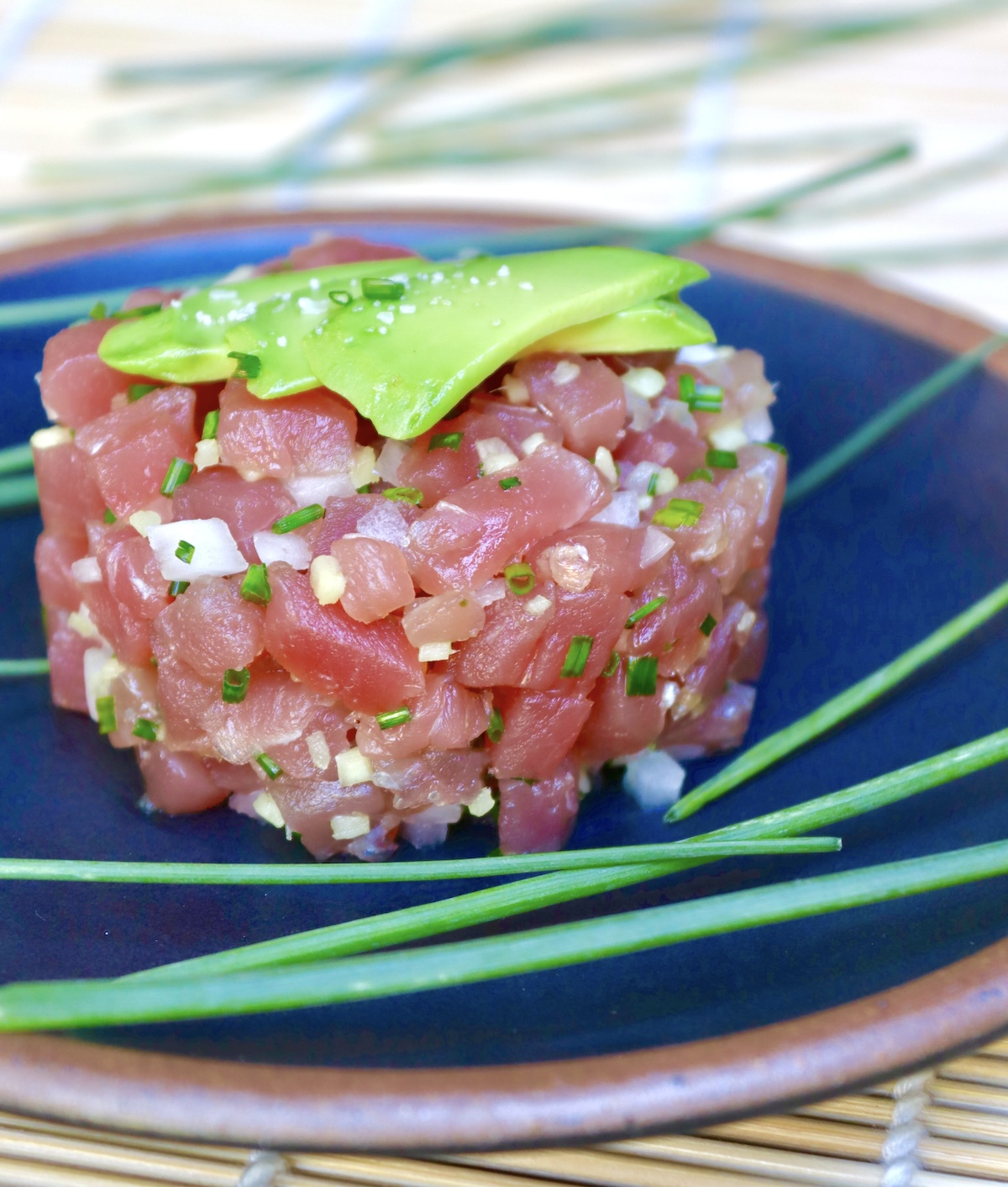 Ahi-Tuna-Tartare-with-Ginger Round mound of tuna tartare with bits of ginger and onion.