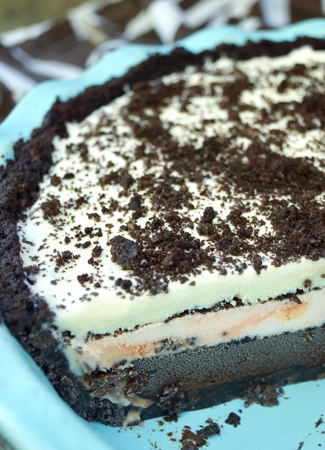 About half of a 3-layer ice cream mud ie in a light blue pie plate.