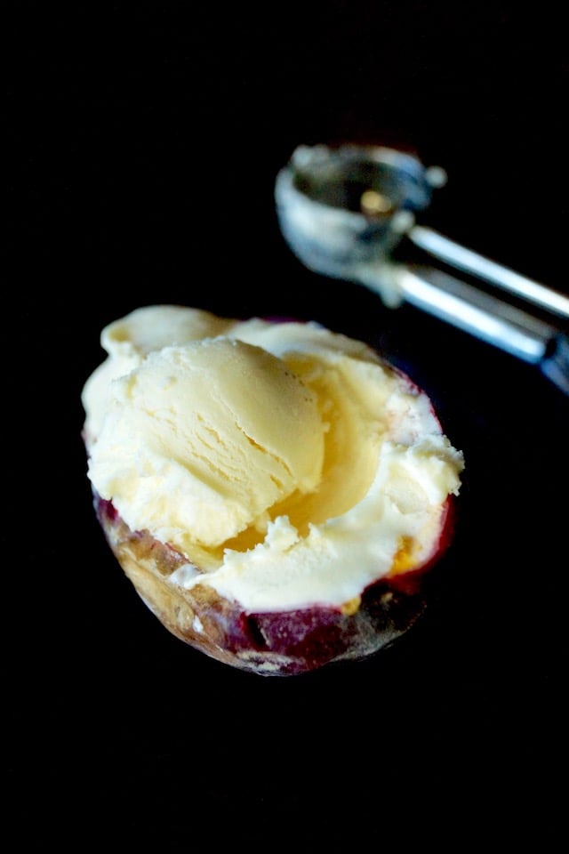 No-Churn Passion Fruit Ice Cream in half of a passion fruit skin with tiny ice cream scoop.