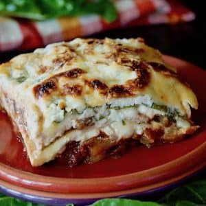 Slice of gluten-free, vegetarian Swiss Chard Lasagna on a red plate.