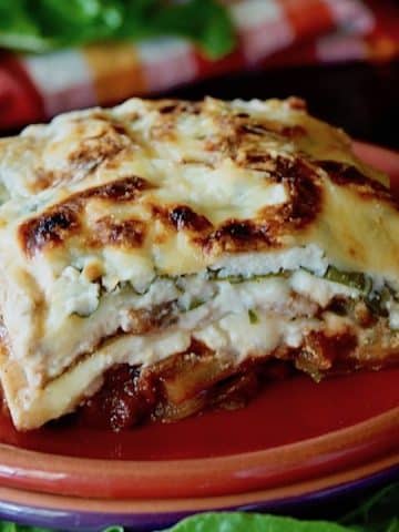 Slice of gluten-free, vegetarian Swiss Chard Lasagna on a red plate.