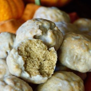 several donut holes with pumpkins behind them