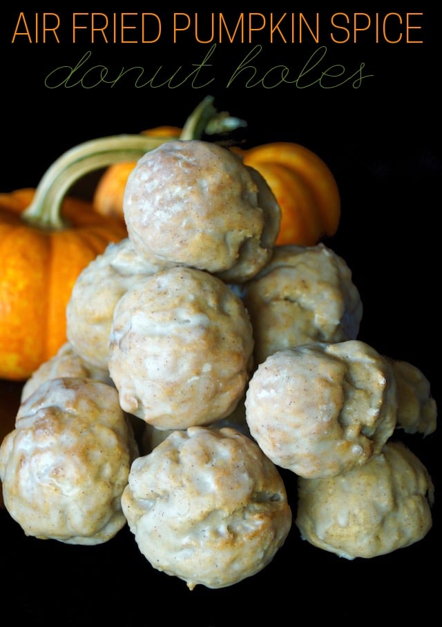 Stack of Air Fried Pumpkin Spice Glazed Donut Holes in front of 2 small pumpkins