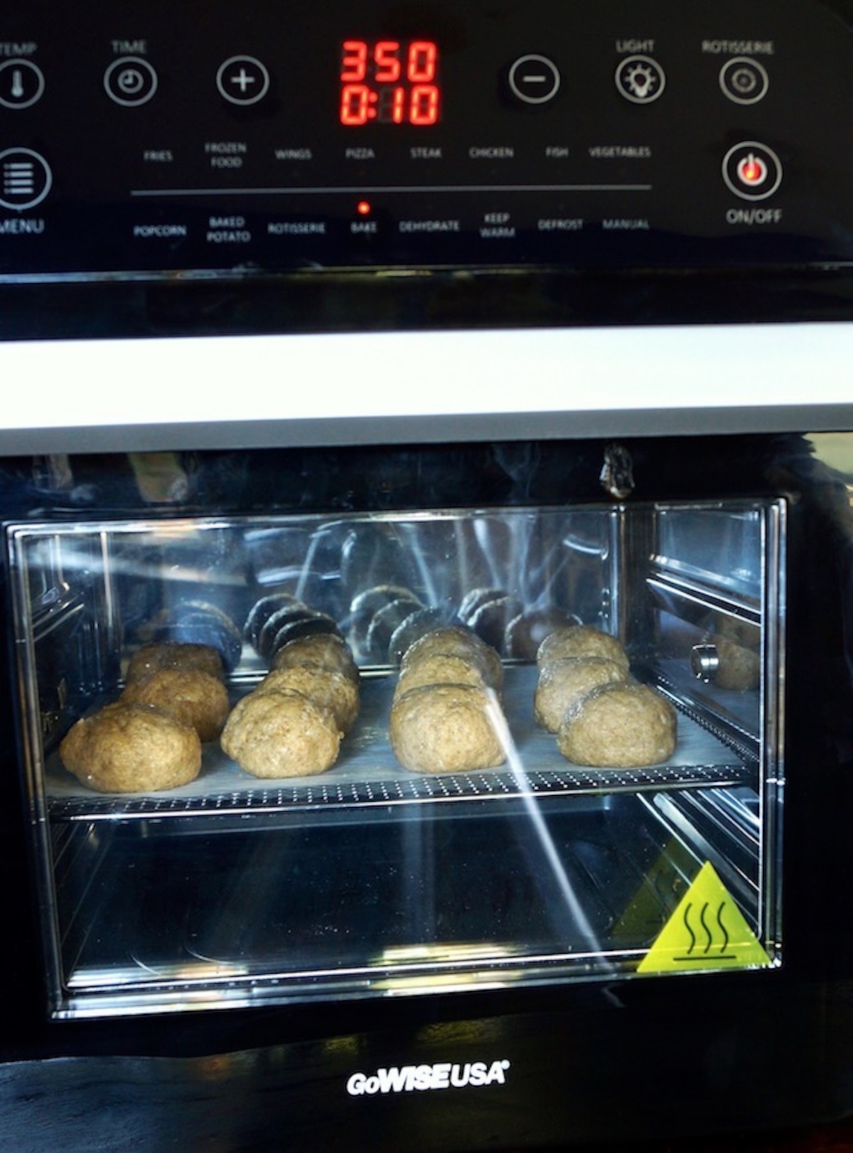 Air fryer with closed door with donut holes baking.