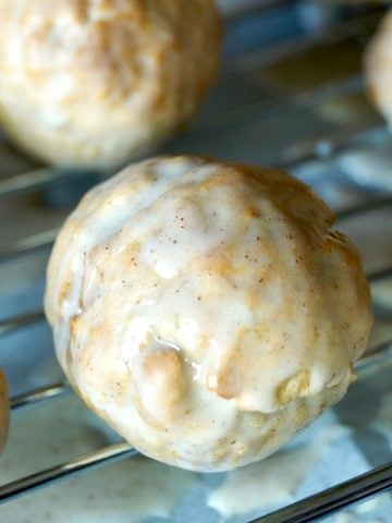 Glazed donut holes on a baking rack.