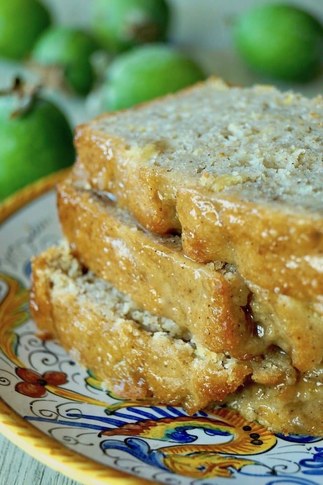 Close up of three slices of Glazed Pineapple Guava Bread on an Italian ceramic, gold-rimmed plate.