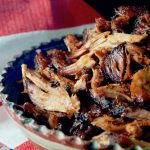 terra cotta bowl overflowing with spiced pulled pork pieces