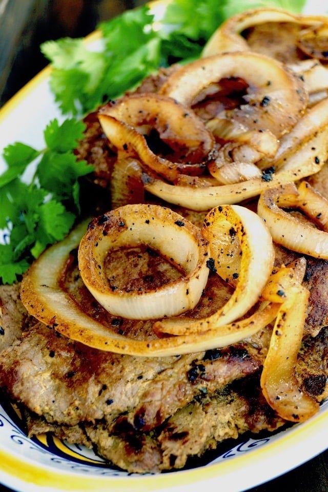 Bistec Encebollado with lots of golden onions on top.