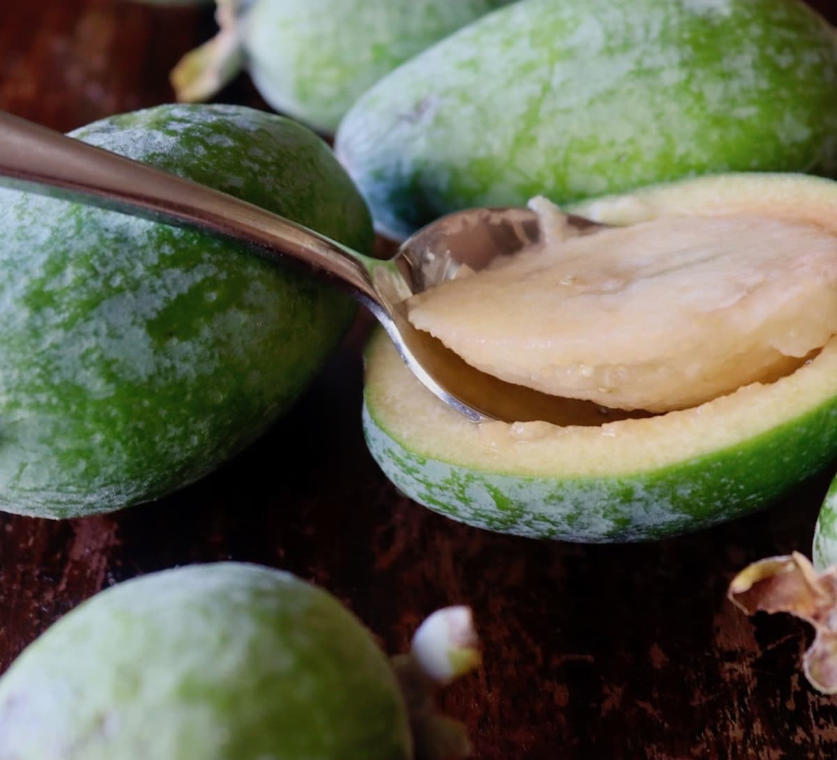 Glazed-Pineapple-Guava-Bread Pineapple guava sliced in half with a spoon scooping out the flesh.