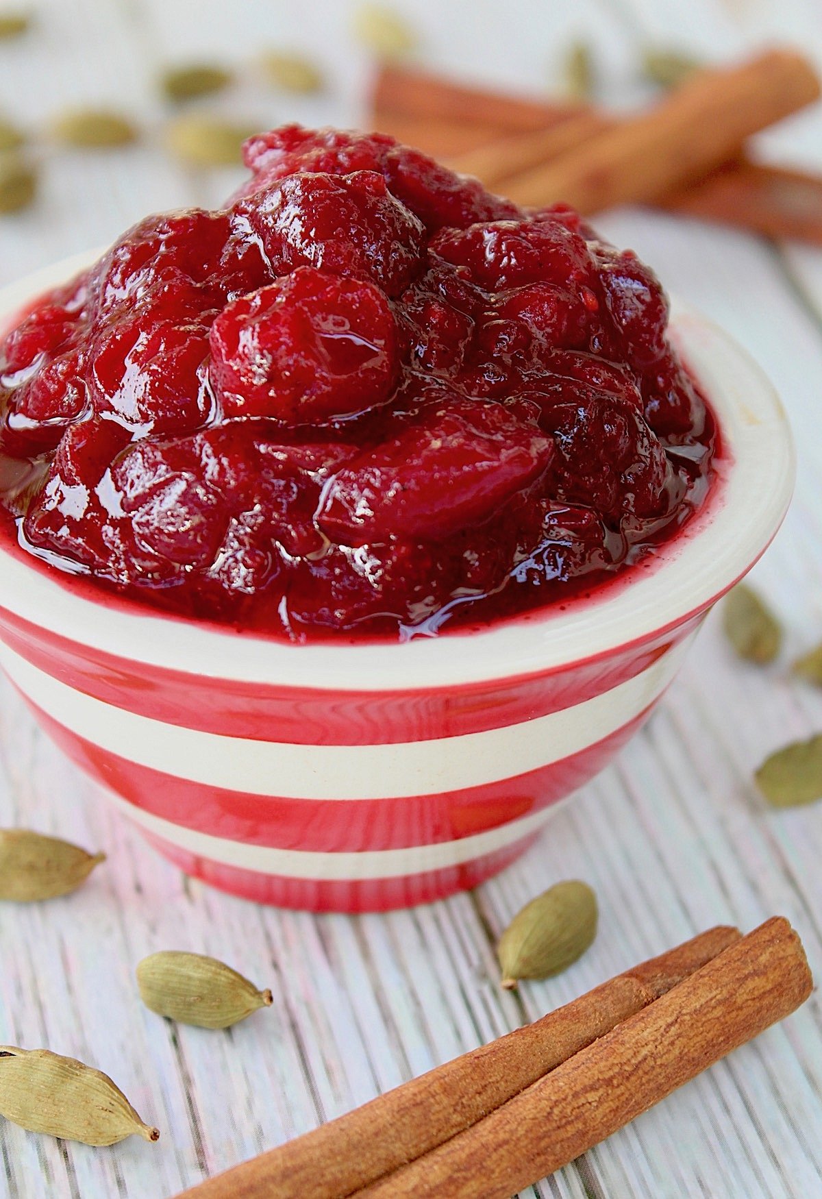 red and white striped bowl filled with spiced cranberry sauce