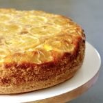 Whole Lemon Olive Oil Cake on white wood cake stand.