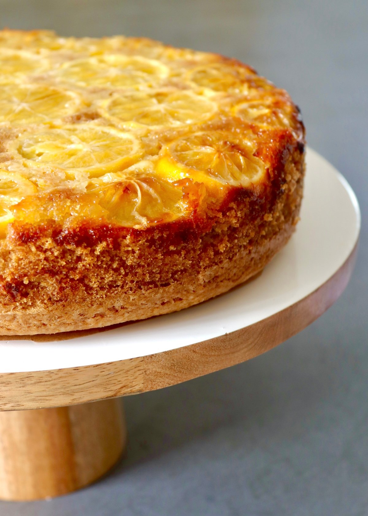 Gluten-Free-Meyer-Lemon-Cake-with-Olive-Oil Whole Lemon Olive Oil Cake on white wood cake stand.